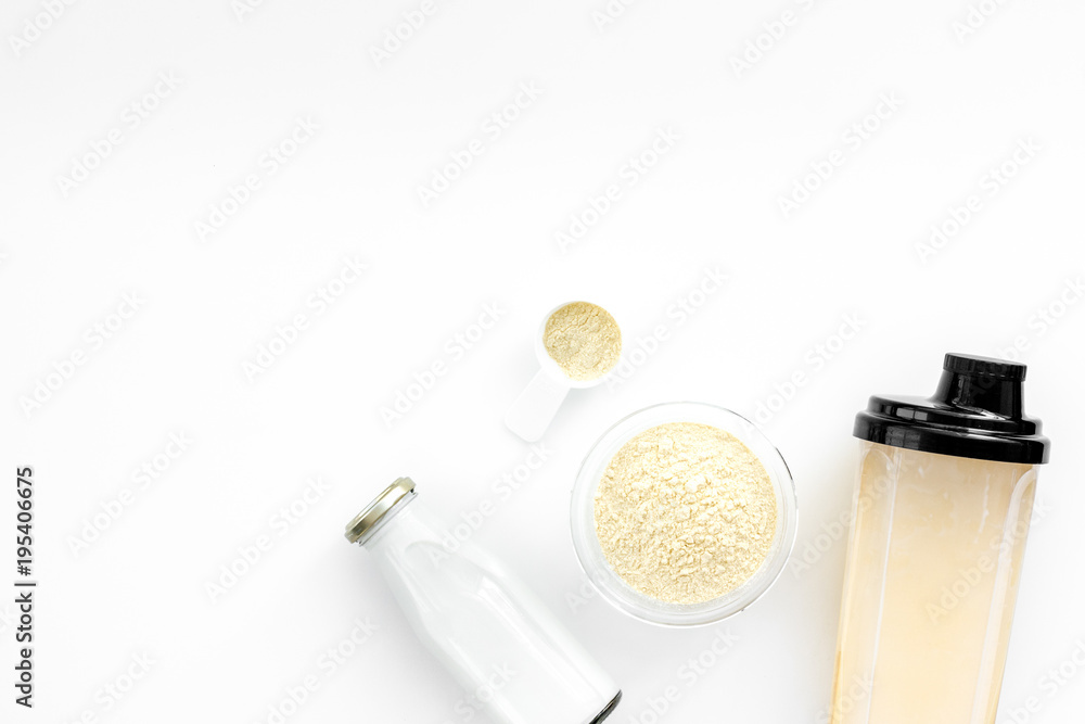 Sports nutrition. Scoop of protein near shaker on white background top view copy space Sports nutrition. Scoop of protein near shaker on white background top view copy space