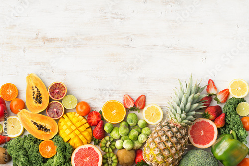 Fruits and vegetables rich in vitamin C, oranges mango grapefruit kiwi kale pepper pineapple lemon sprouts papaya broccoli, on wooden white table, top view, copy space, selective focus