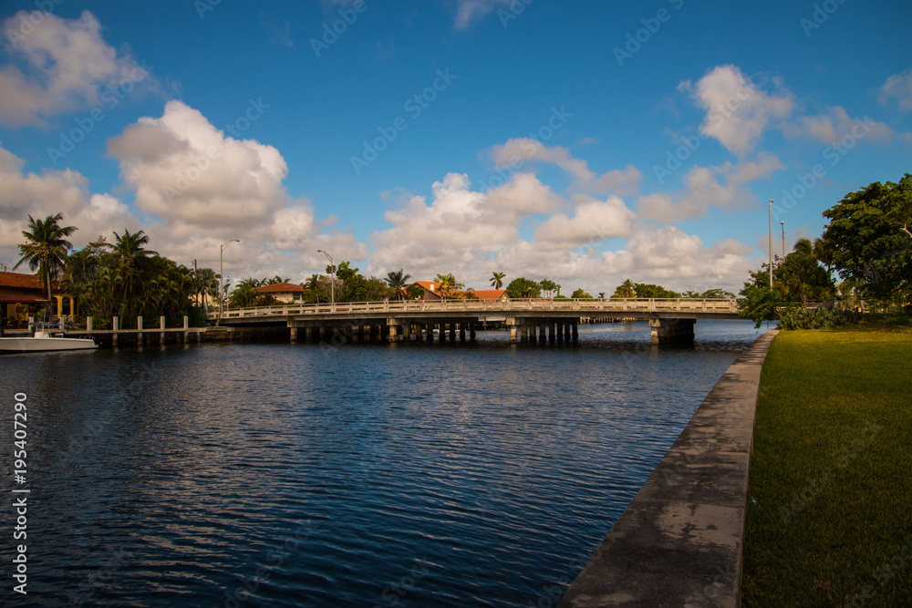 Bridge over waterway with blue sky and puffy white clouds