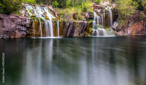 Long exposure waterfall over rocks with reflections in water