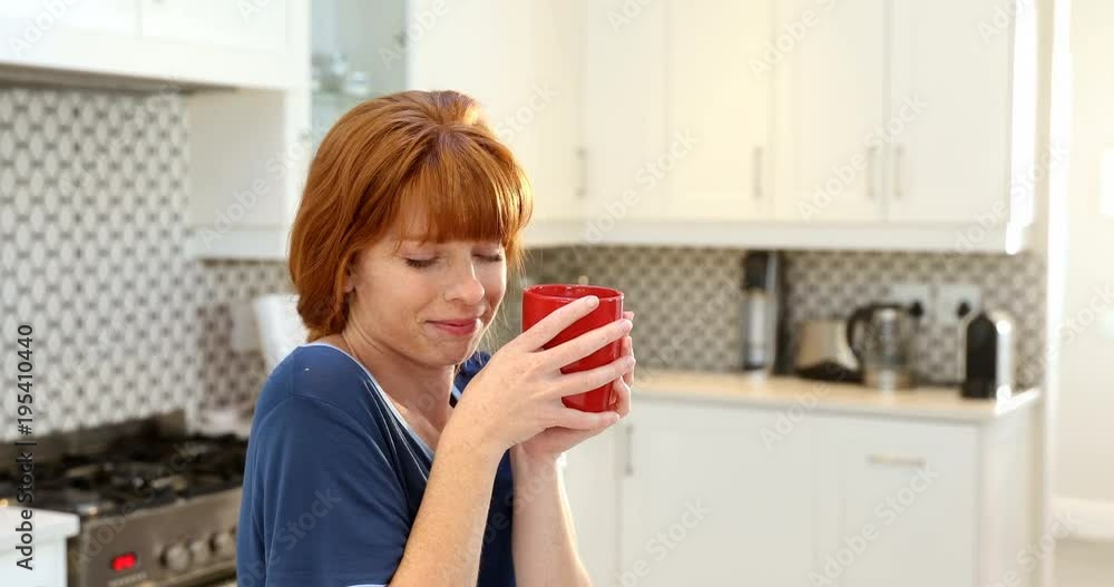 Beautiful woman having coffee in kitchen Beautiful woman having coffee in kitchen