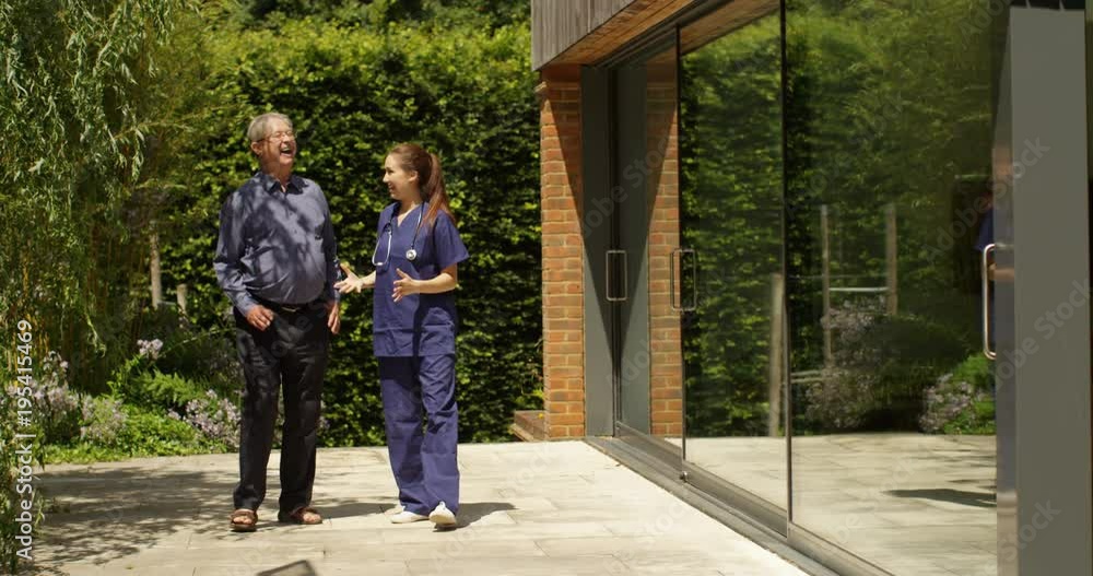 4K Caring nurse giving good news to senior man as they walk in hospital garden. Slow motion 4K Caring nurse giving good news to senior man as they walk in hospital garden. Slow motion