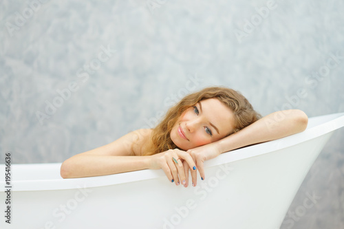 young woman laying in bathtub.relaxed time in bathroom.young woman relaxing in bathtub.