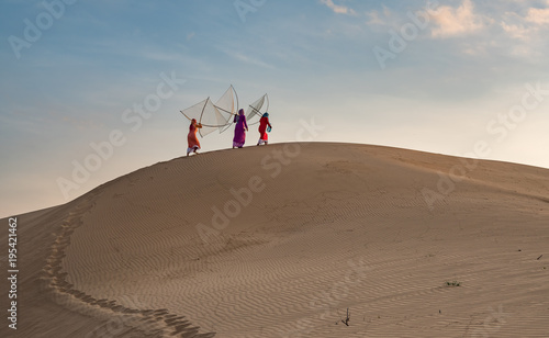 Cham women are walking on sand dunes in Nam Cuong  Phan Rang  Viet Nam