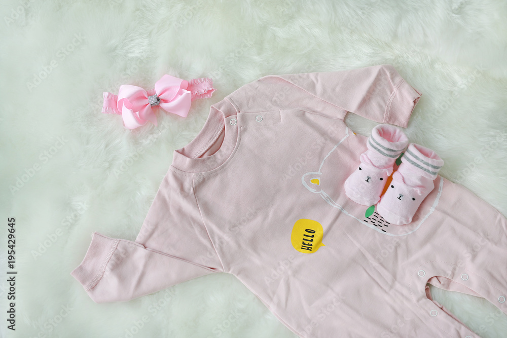 Collection items of bodysuits for newborn babies with socks on white fur background.
Collection items of bodysuits for newborn babies with socks on white fur background.