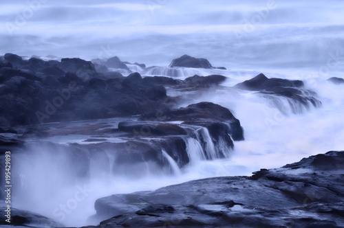 Fototapeta Naklejka Na Ścianę i Meble -  Moody Ocean Seascape landscape on rocky beach with misty waves