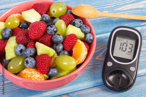 Fruit salad and glucometer for checking sugar level, diabetes, healthy lifestyle and nutrition concept