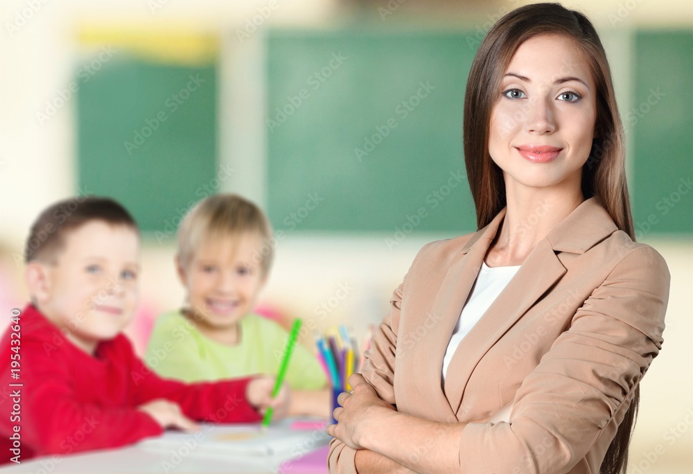 Young female teacher with schoolchild in classroom