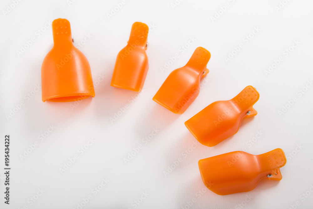 orange clothespins for removing nail polish on a white background orange clothespins for removing nail polish on a white background