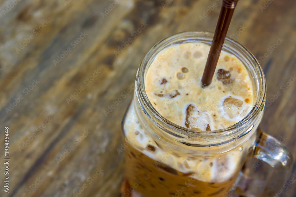 Iced coffee in glass on wooden table background Iced coffee in glass on wooden table background