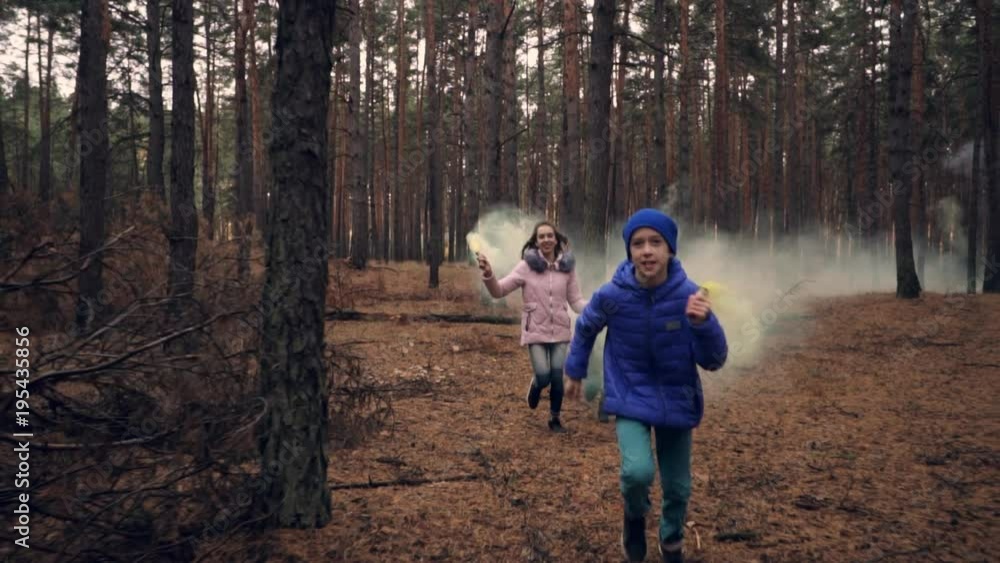 Children running with smoke bombs in forest in slow motion Children running with smoke bombs in forest in slow motion