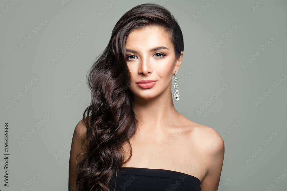 Beautiful Brunette Woman with Long Curly Hair on Gray Background. Cute Female Face Beautiful Brunette Woman with Long Curly Hair on Gray Background. Cute Female Face