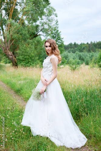 young pretty bride in white wedding dress outdoors, make up and hairstyle