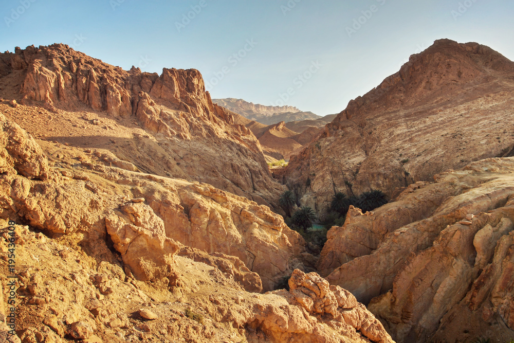 Dry rocks in desert, lit by midday sun. Chebika oasis, Atlas Mountains, Tunisia.
