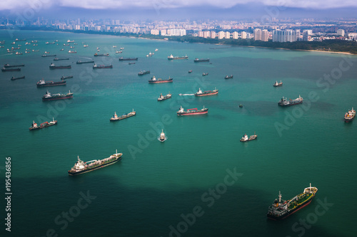 Top view from airplane of Singapore harbor with transportation boat and container ship