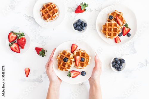 Foto Belgian waffles with fresh strawberry and blueberry on white background