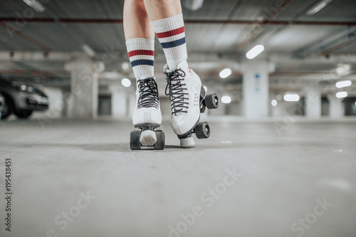 young sexy woman rollerskating in an urban looking garage and posing in a hipster like matter