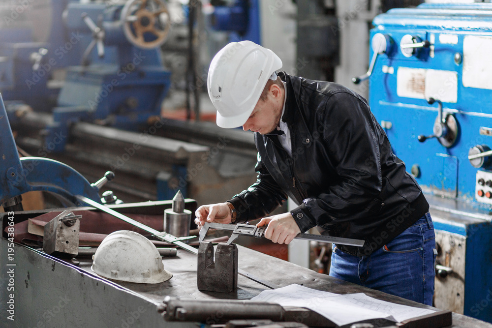 a young successful engineer makes a measurement of the details of the mechanism a young successful engineer makes a measurement of the details of the mechanism
