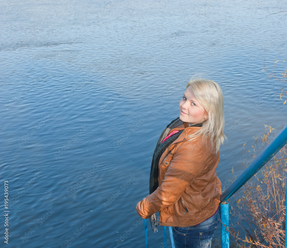 Blonde young girl by the river. Autumn Sunny day Blonde young girl by the river. Autumn Sunny day