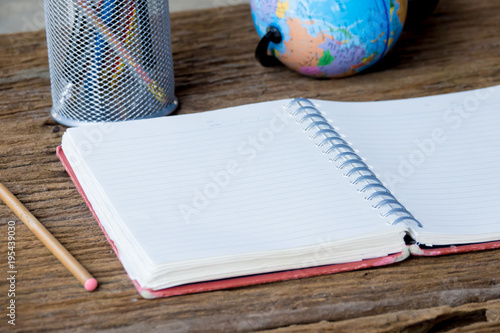 Top view of notebok with pencil on wooden table. Emtry page for text. photo