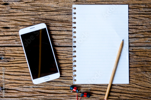 Top view of notebok with pencil, smart phone and calculator on wooden table. Emtry page for text. photo