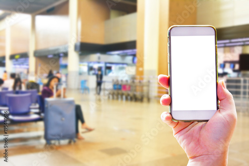 People hand use cellphone at the hall airport background with copy space on screen for using mobile app about activities in the airport or checking flight plan