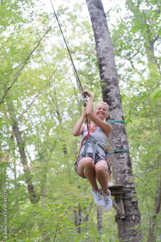 happy enthusiastic woman having great time in the adventure park
