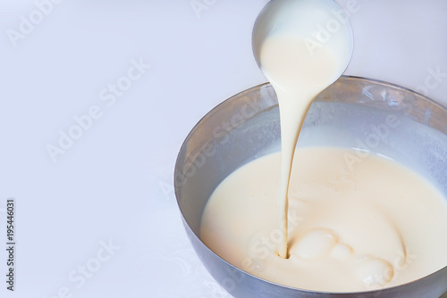 Kneading dough for pancakes. Batter for pancakes is poured from a large spoon