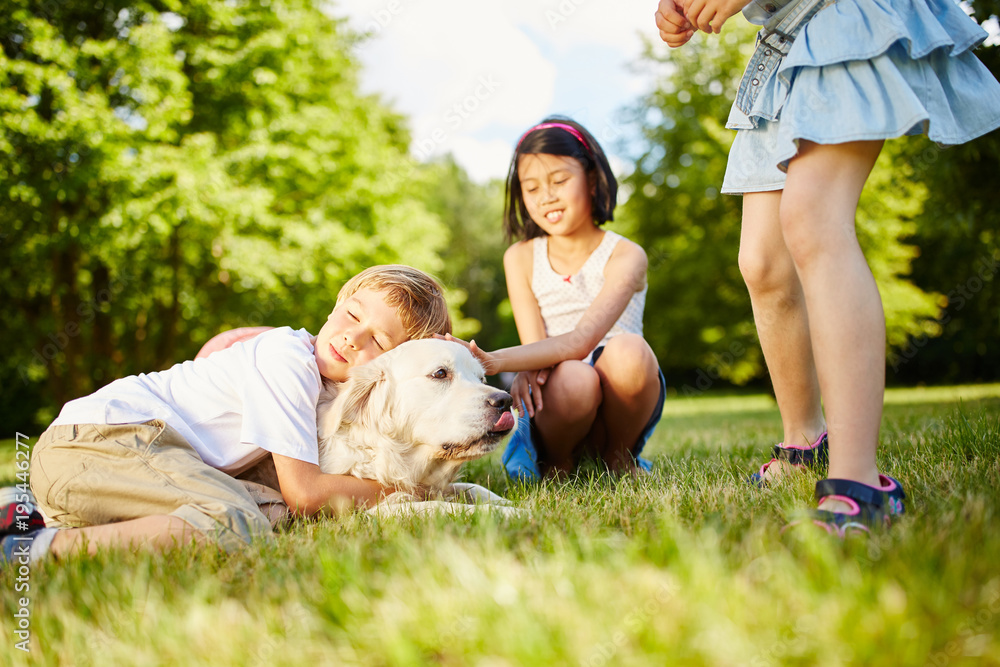 Obraz premium Junge kuschelt mit einem Golden Retriever