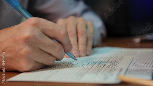 A man fills the paper. Hands close up