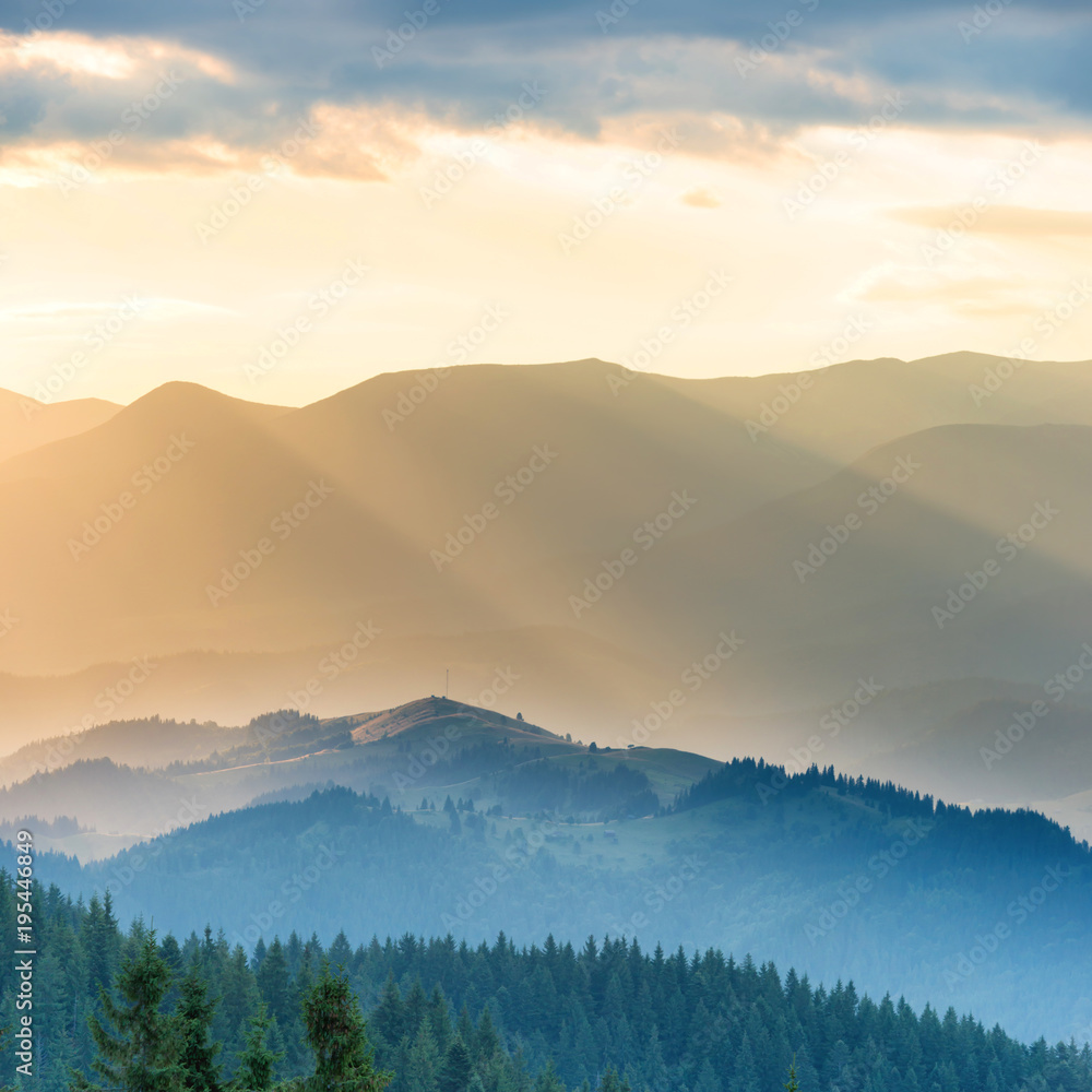 Obraz premium Piękny zachód słońca w górach. Krajobraz ze słońcem wpadającym przez pomarańczowe chmury