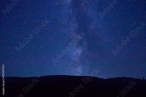 Night dark blue sky with many stars and milky way galaxy above a mountain © Pavlo Vakhrushev