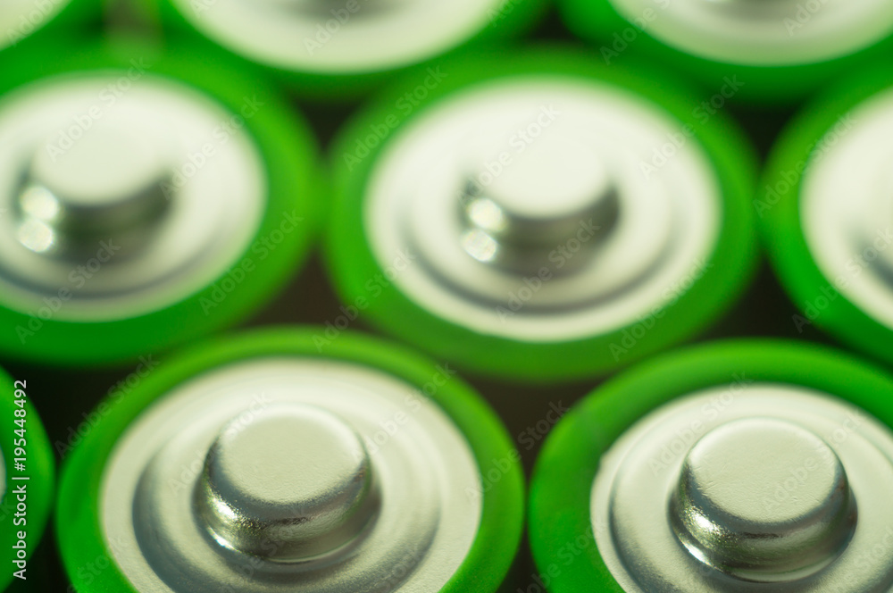 Top of the battery. Heap of green batteries. Background on electronics. Top of the battery. Heap of green batteries. Background on electronics.