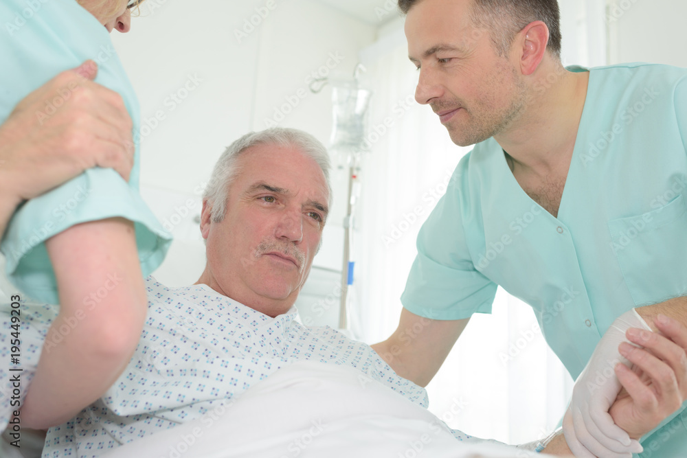 caretaker helping senior patient in bed caretaker helping senior patient in bed
