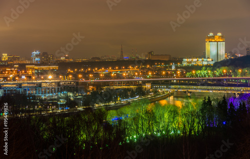 Nightview of Moscow city with Luzhniki stadium, the Russian Academy of Sciences building, the Railway bridge over the Moskva river and open air underground station Vorobyovy Gory. Evening illumination