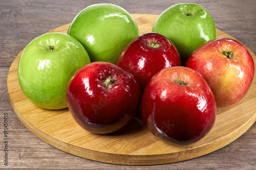 Świeże, czerwone i zielone jabłka na drewnianej desce 