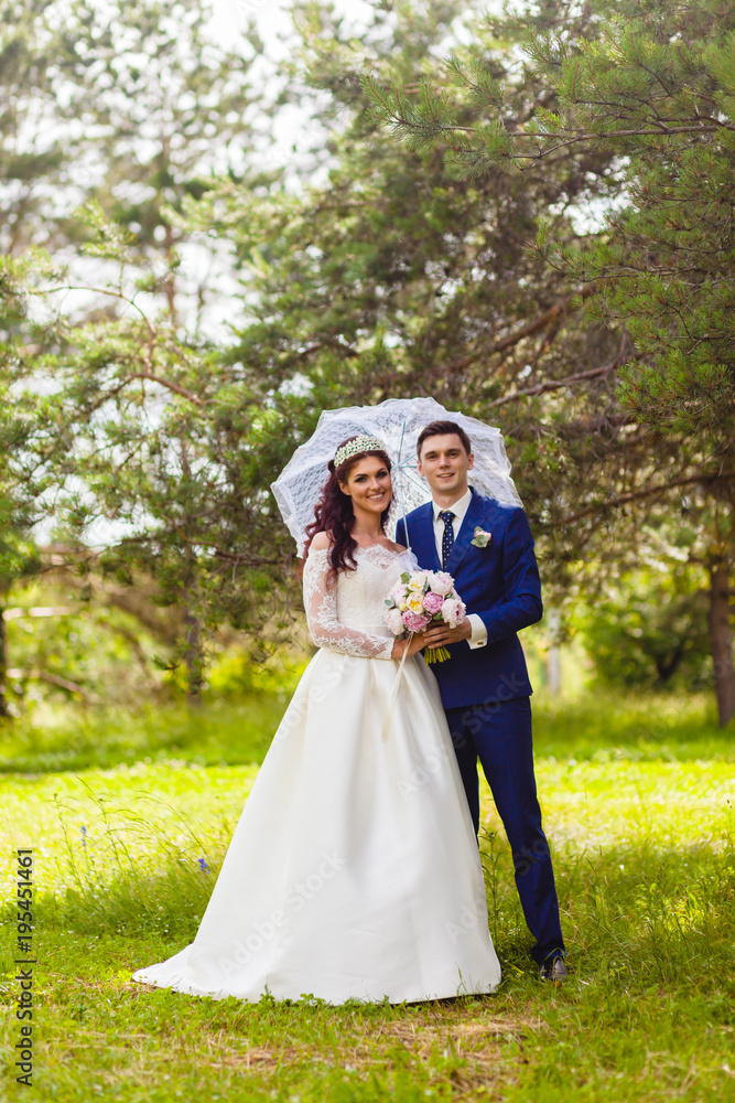 Beautiful couple newlyweds with the white umbrella Beautiful couple newlyweds with the white umbrella