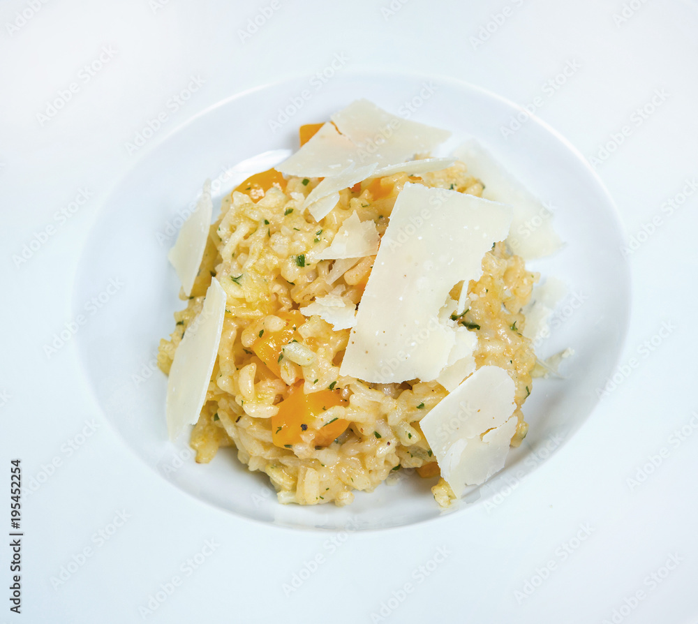 Italian dish risotto with wild white mushrooms and Parmesan cheese in a white plate Italian dish risotto with wild white mushrooms and Parmesan cheese in a white plate