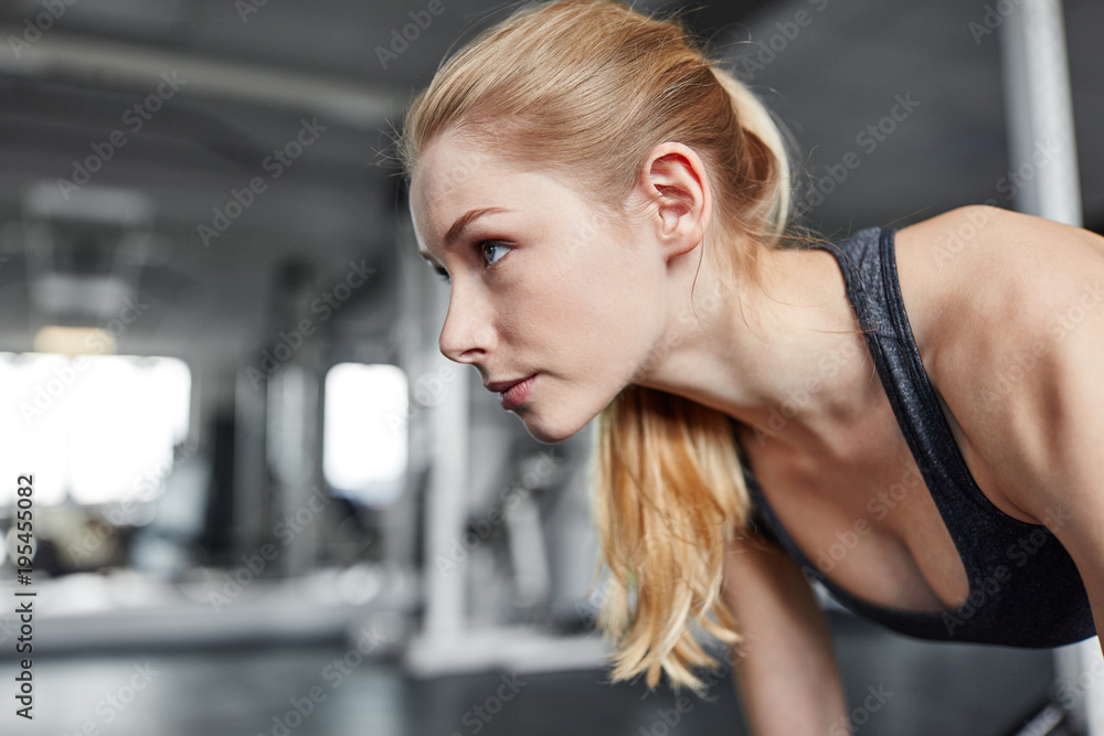 Junge Frau macht Liegestütze im Fitnessstudio Junge Frau macht Liegestütze im Fitnessstudio