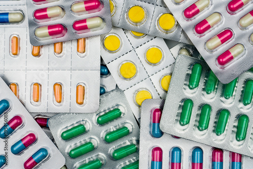 Top view of colorful tablets and capsules pills in blister packs. Global health care and drug use with reasonable concept. Full frame of pile of pills photo