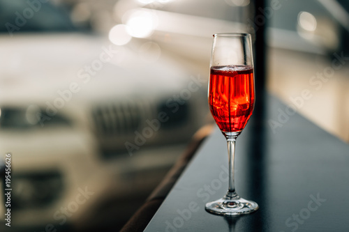 Red Cocktail in Champagne Glass near the Window in the Bar with Amazing Blurred Background, Free Space for Text