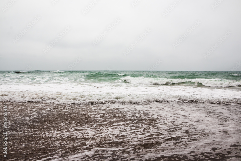 Coast, waves and beach with yellow sand and pebbles Coast, waves and beach with yellow sand and pebbles