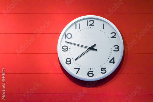 black and white clock wall on red wooden background.