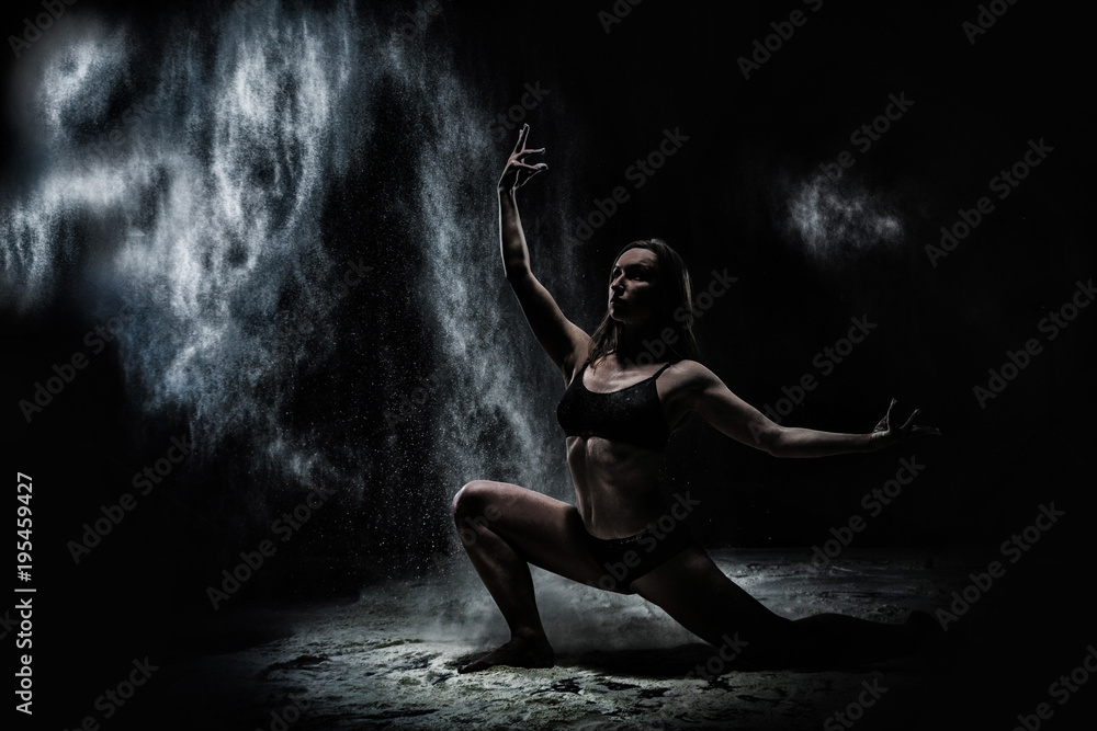 Naklejka premium Girl dansing with flour on black background