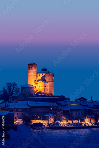 Serralunga castle during a cold winter night with snow in langhe region, Italy