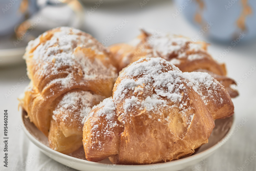 Croissants with jam on a plate and coffee on a white background. Croissants with jam on a plate and coffee on a white background.