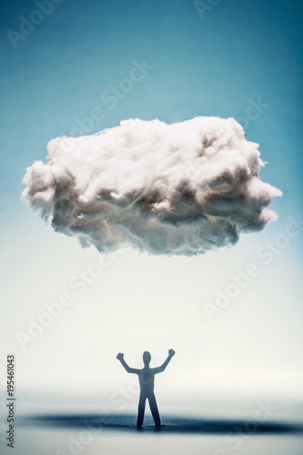 Angry man with clenched fists standing under a cloud.