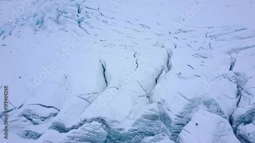 Aerial view of crevasses with visible layers of ice. Cracked glacier from above.