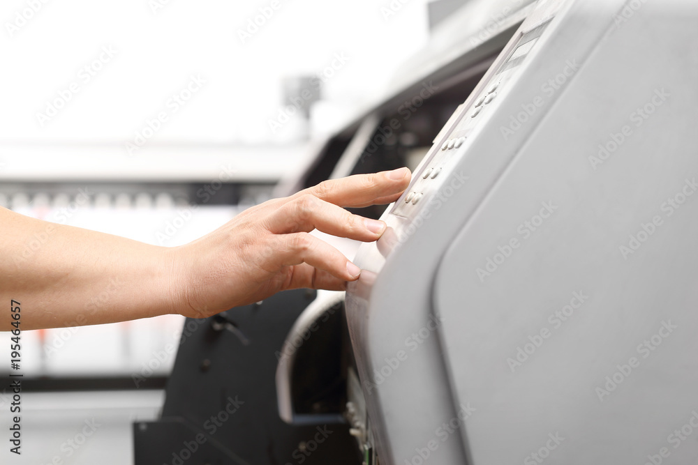 Pracownik obsługuje maszynę drukującą. - obrazy, fototapety, plakaty 