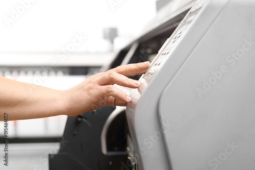 Pracownik obsługuje maszynę drukującą.